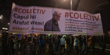 Pe un banner de câțiva metri, participanții la marșul de comemorare a victimelor de la Colectiv au cerut demisia lui Raed Arafat