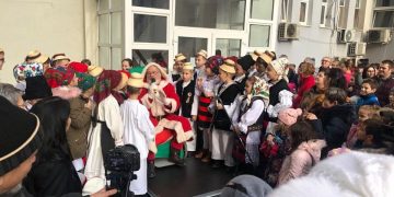 Moș Crăciun, ajutat de unul dintre renii săi, cu daruri pentru copiii angajaților Spitalului Județean